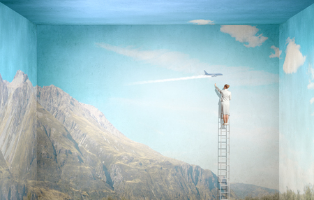 Businesswoman standing on ladder and climbing up to window. Mixed mediaの写真素材