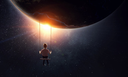 Cute little boy riding on swing.