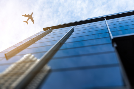 Bottom angle view of airplane in sky over city buildings