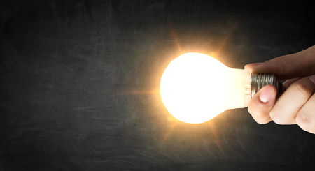 Glowing light bulb in hand as symbol for bright ideaの写真素材