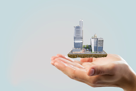 Close of businessman hand holding mini exterior model in palms. Mixed mediaの写真素材