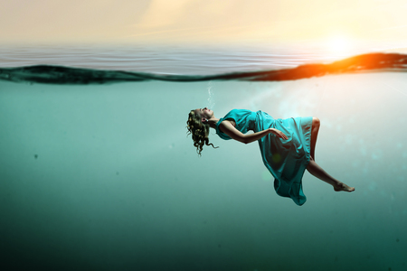 Woman dancer in clear blue waterの写真素材