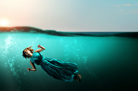 Woman dancer in clear blue waterの写真素材