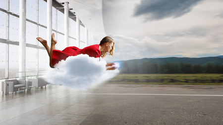 Woman fly in air and use mobile. Mixed mediaの写真素材