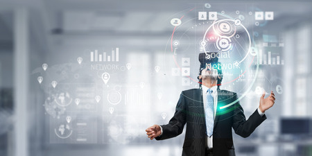 Businessman having VR experience. Mixed media