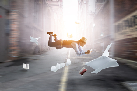Smiling joyful levitating young man. Mixed mediaの写真素材