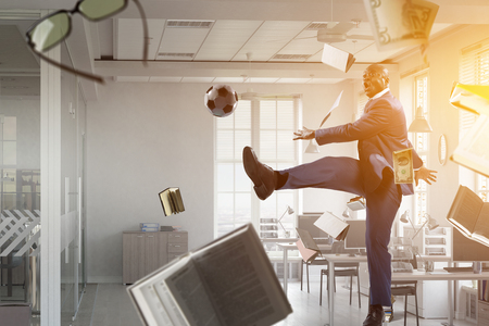 Black businessman in a suit playing footbalの写真素材