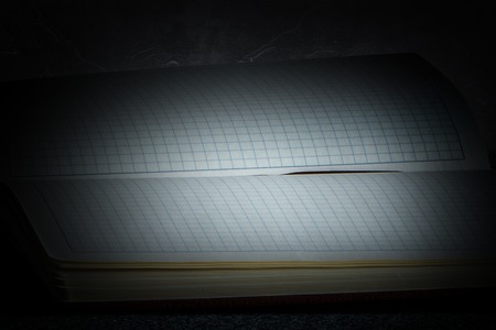 Notebook open on dark backgroundの写真素材