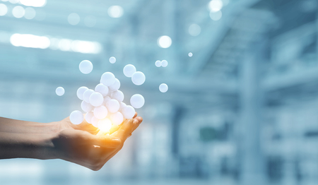 Female hand holding a bunch of spheres levitating above. Mixed mediaの写真素材