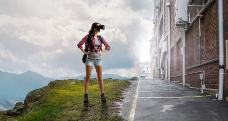 Travelling female tourist with backpack and VR helmetの写真素材