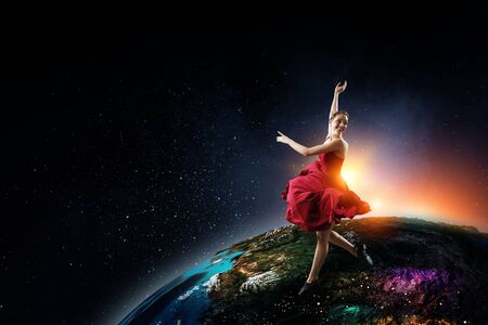 Young and beautiful female dancer in a red dress. Mixed mediaの写真素材