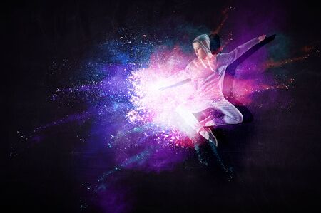 Modern female dancer jumping in hoodie with colourful splashes background. Mixed mediaの写真素材