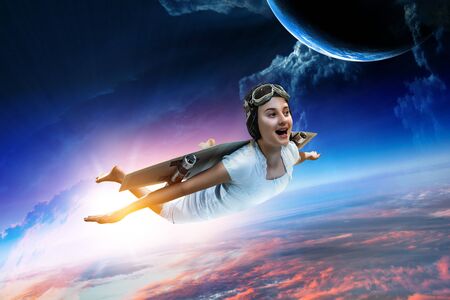 Girl flying with self-made plane wing. Mixed mediaの写真素材