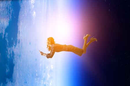 Joyful beautiful young levitating businesswoman. Mixed media