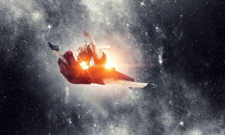 Young and beautiful female dancer in a red dress. Mixed mediaの写真素材