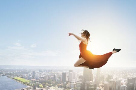 Young and beautiful female dancer in a red dress. Mixed mediaの写真素材