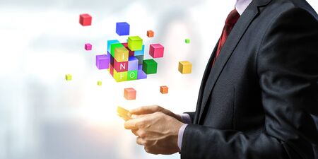 Businessman holding a tabalet with cube puzzle levitating above. Mixed media