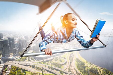 Young woman flying on hang glider. Mixed mediaの写真素材