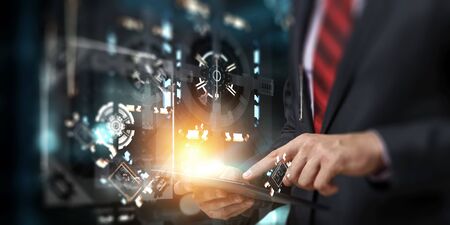 Close up of businessman`s hand holding a tablet, with a mechanism on the background. Mixed media
