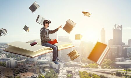 Virtual reality experience, young man in VR glasses. Mixed mediaの写真素材
