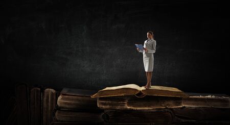 Young woman reading a book. Mixed mediaの写真素材