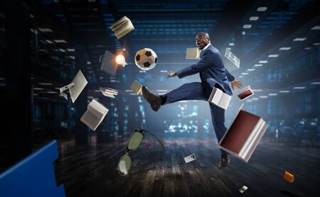 Black businessman in a suit playing footbalの写真素材