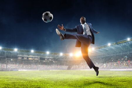 Black businessman in a suit playing footbalの写真素材