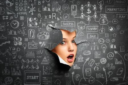 Woman looking through a hole in banner. Mixed mediaの写真素材