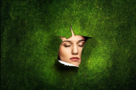 Woman looking through a hole in banner. Mixed mediaの写真素材