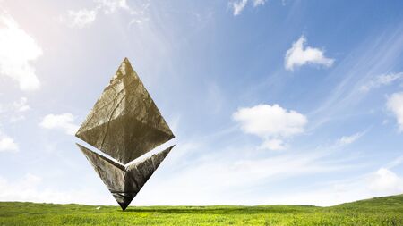Ethereum symbol made of stone on green grass