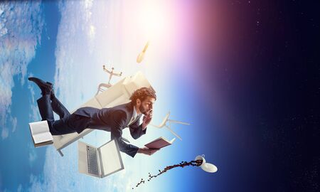 Man flies and works on laptop. Mixed mediaの写真素材