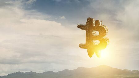 Bitcoin symbol made of stone on landscape backgroundの写真素材