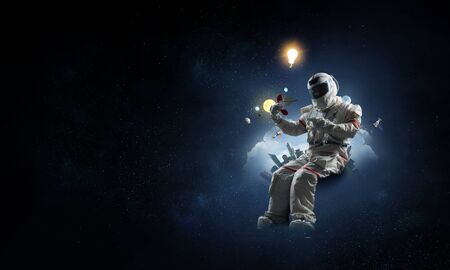 Astronaut in a space-suit sitting on a playful globe on starry sky background