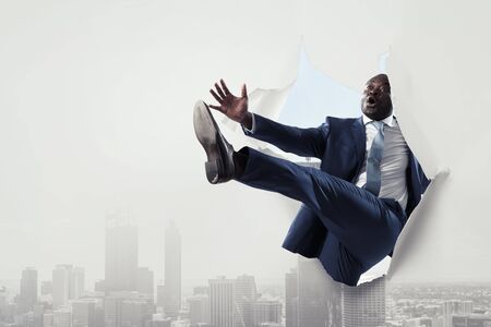 Breakthrough paper hole with a black businessmanの写真素材