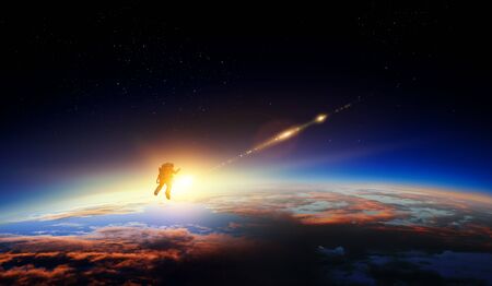 Astronaut in a space-suit in outer space beside a planetの写真素材