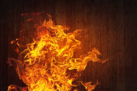 Fire flames against wooden wall or surfaceの写真素材