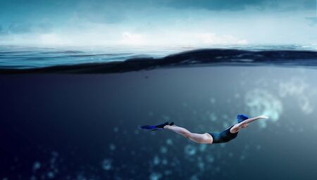 Young woman swimming in clear blue water. Mixed mediaの写真素材