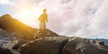 Young athlete running outdoor in mountains. Mixed mediaの写真素材