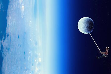 Fantasy image with kid riding swing in space