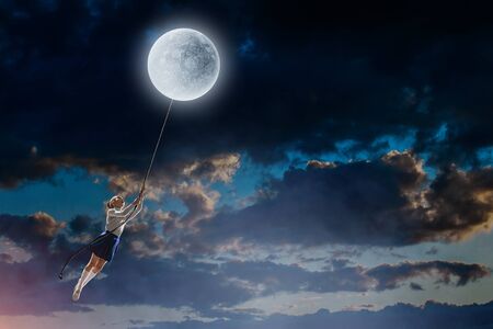 Girl of school age flying moon balloon. Mixed mediaの写真素材