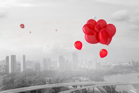 Red balloons flying away in sunset skyの写真素材