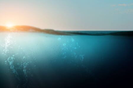 Blue under water at sunset with rays of sunの写真素材