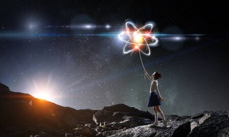 Little girl holding atom molecule concept. Mixed media