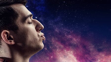 Man giving a kiss with galaxy background. Mixed mediaの写真素材