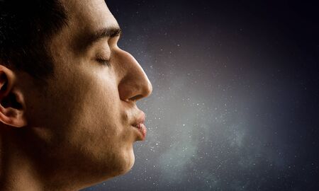 Profile of man kissing against dark sky backgroundの写真素材