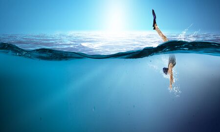 Young woman swimming in clear blue water. Mixed mediaの写真素材