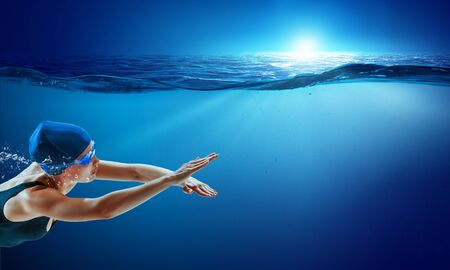 Young woman swimming in clear blue water. Mixed mediaの写真素材