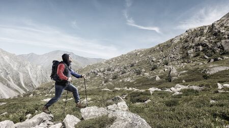 Male tourist with backpack reaching the top. Mixed media