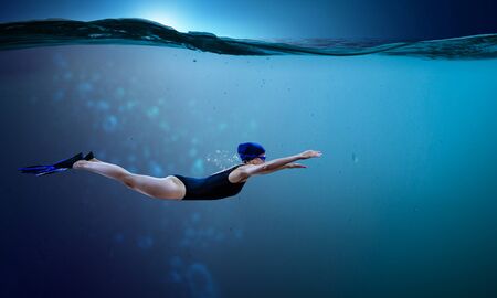 Young woman swimming in clear blue water. Mixed mediaの写真素材