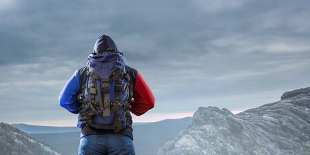 Male tourist with backpack reaching the top. Mixed media